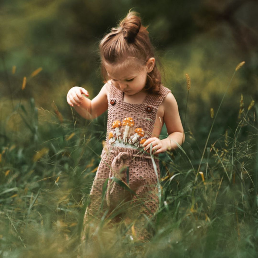 Gender-neutral Mushroom Romper handmade in cotton bamboo with crochet mushroom motifs — artisan-made, machine washable, sizes 0-3M to 6/7Y by JuneBee Baby.
