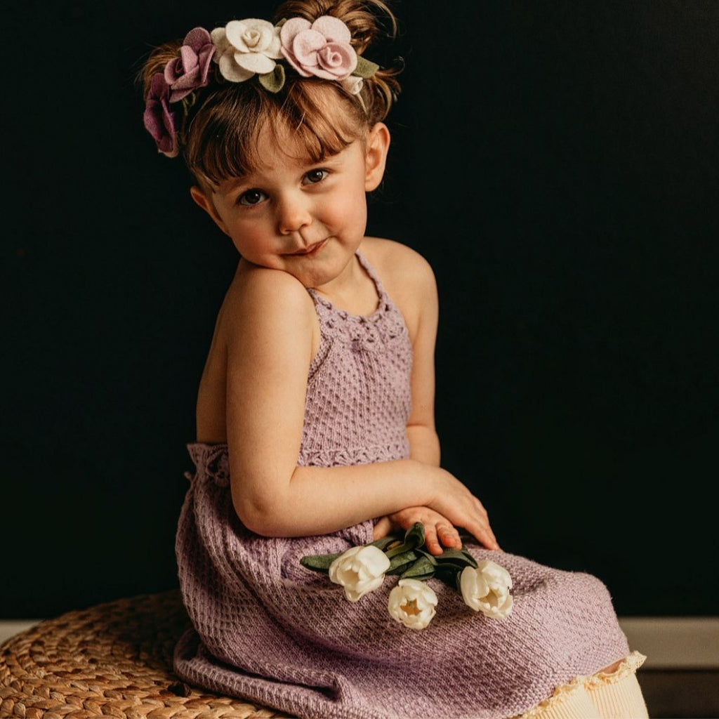 Hand-knit T-back dress for girls in cotton bamboo — flowy crochet back design, adjustable neckline, available in baby, kids, and doll sizes by JuneBee Baby.