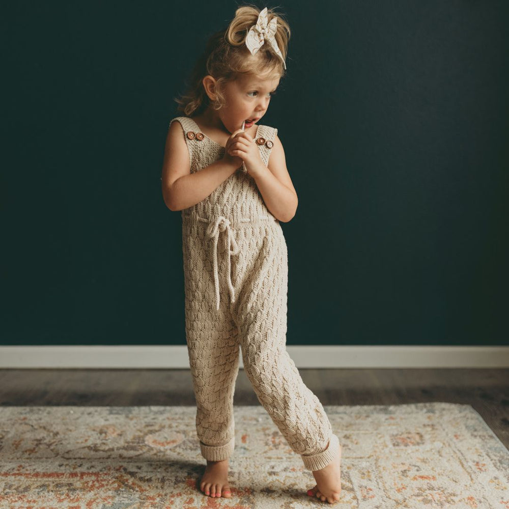 Hand-knit gender-neutral Dakota Playsuit in cotton bamboo — machine washable, durable artisan knitwear for babies and kids by JuneBee Baby.