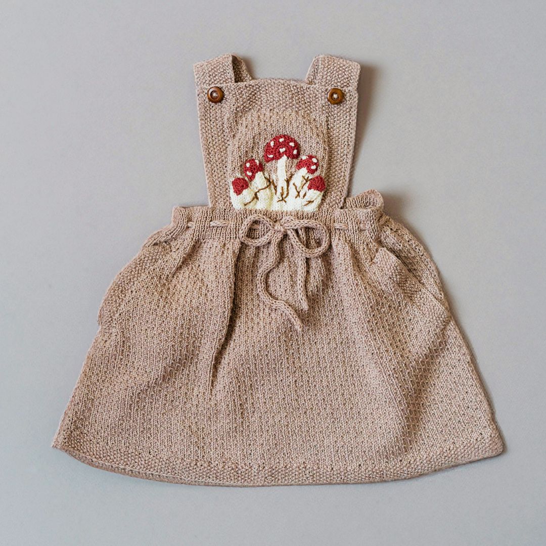 Hand knitted mushroom pinafore for kids in soft cotton and bamboo yarn, artisan made by JuneBee Baby