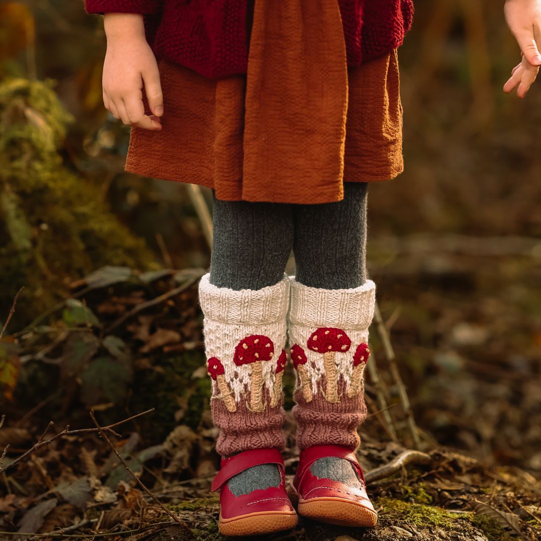 Toddler girl wearing hand-knit mushroom leg warmers in creamy light green cotton bamboo, baby girl mushroom outfit.