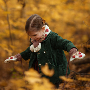 Child wearing hand-knit mushroom neck scarf in creamy green cotton bamboo, unisex slow fashion knitwear by JuneBee Baby.