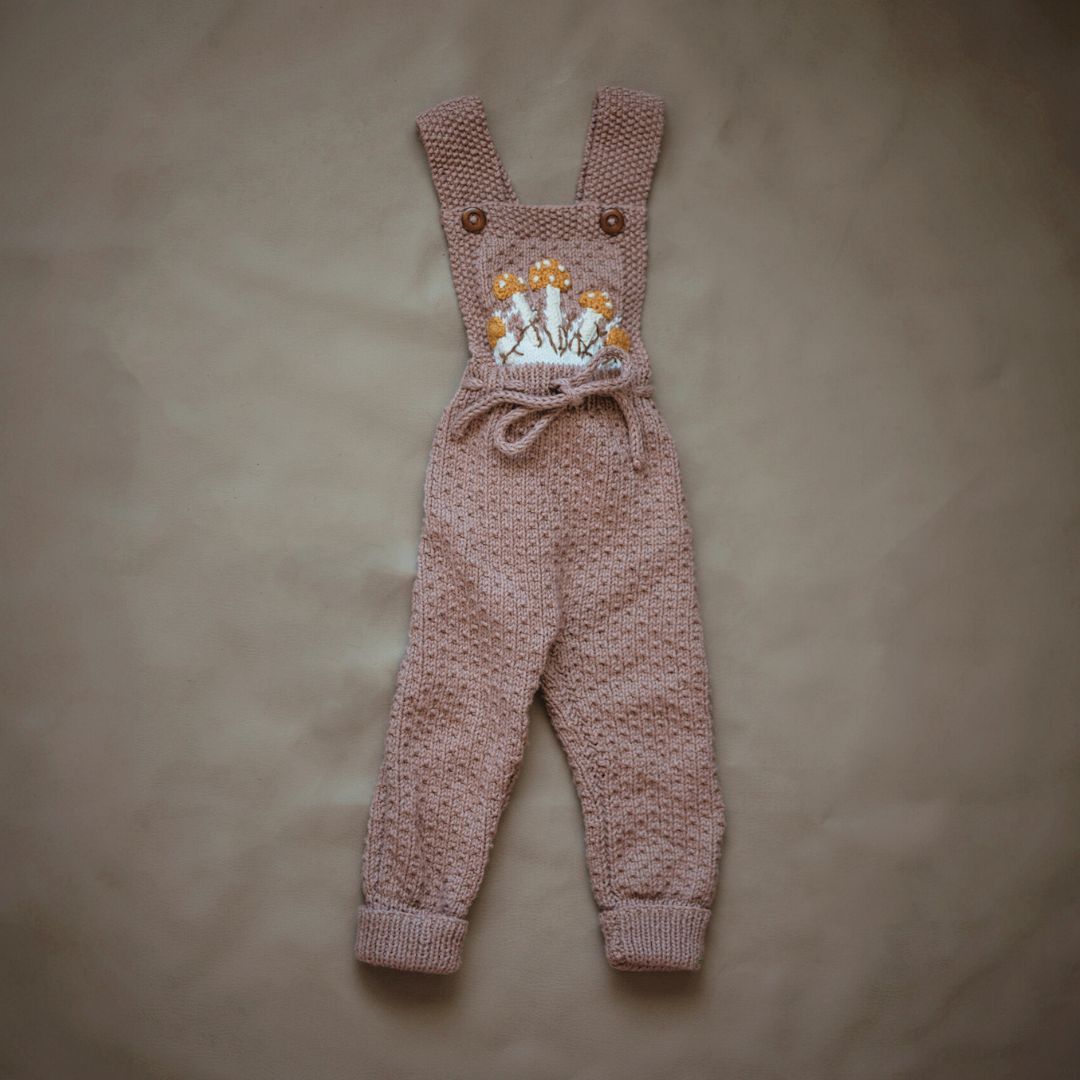Flat lay of hand-knit mushroom romper in blush brown cotton bamboo, baby mushroom outfit by JuneBee Baby