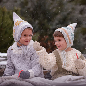 Children wearing unisex Nordic pixie hat in hand knitted cotton bamboo with snowflake motifs.